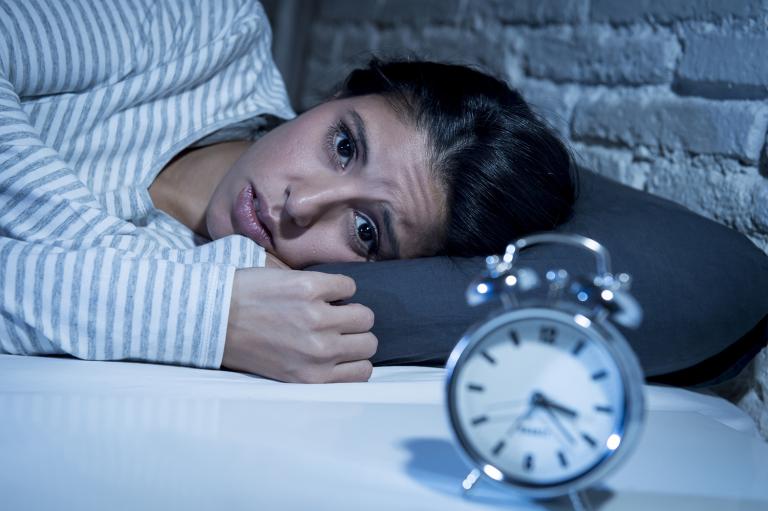 a woman staring at an alarm clock all night