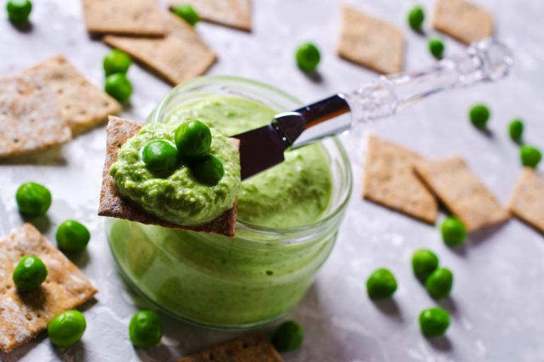 A jar of sweet green pea dip, with crackers